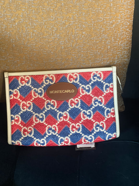 Beautiful Montecarlo pouch/clutch featuring a bold red, blue, and white GG geometric monogram pattern with cream trim and a brown leather Montecarlo logo patch.